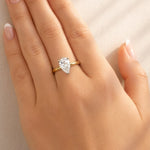 Gold ring with a lab grown diamond on a hand against a neutral background at LeGassick.