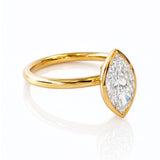 Gold ring with a marquise-shaped lab created diamond on a white background