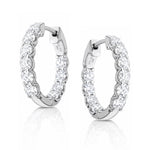 Pair of white gold hoop earrings with clear lab grown diamonds on a white background