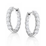Pair of white gold hoop earrings with clear lab grown diamonds on a white background
