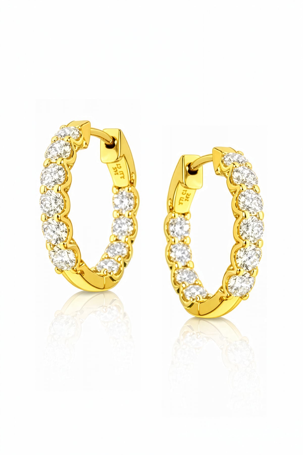 A pair of yellow gold hoop earrings with clear lab grown diamonds on a white background
