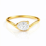 Gold ring with a pear cut lab grown diamond on a white background