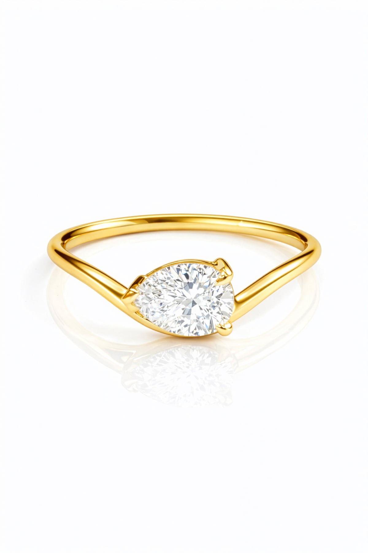 Gold ring with a pear cut lab grown diamond on a white background