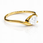 Gold ring with a pear cut lab grown diamond on a white background