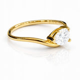 Gold ring with a pear cut lab grown diamond on a white background