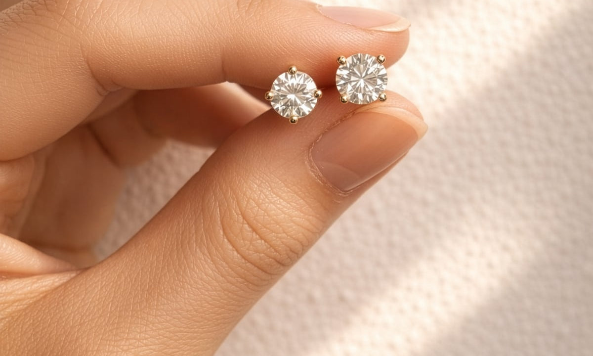 Hand holding a pair of lab diamond stud earrings against a soft background at LeGassick, Gold Coast, Australia.
