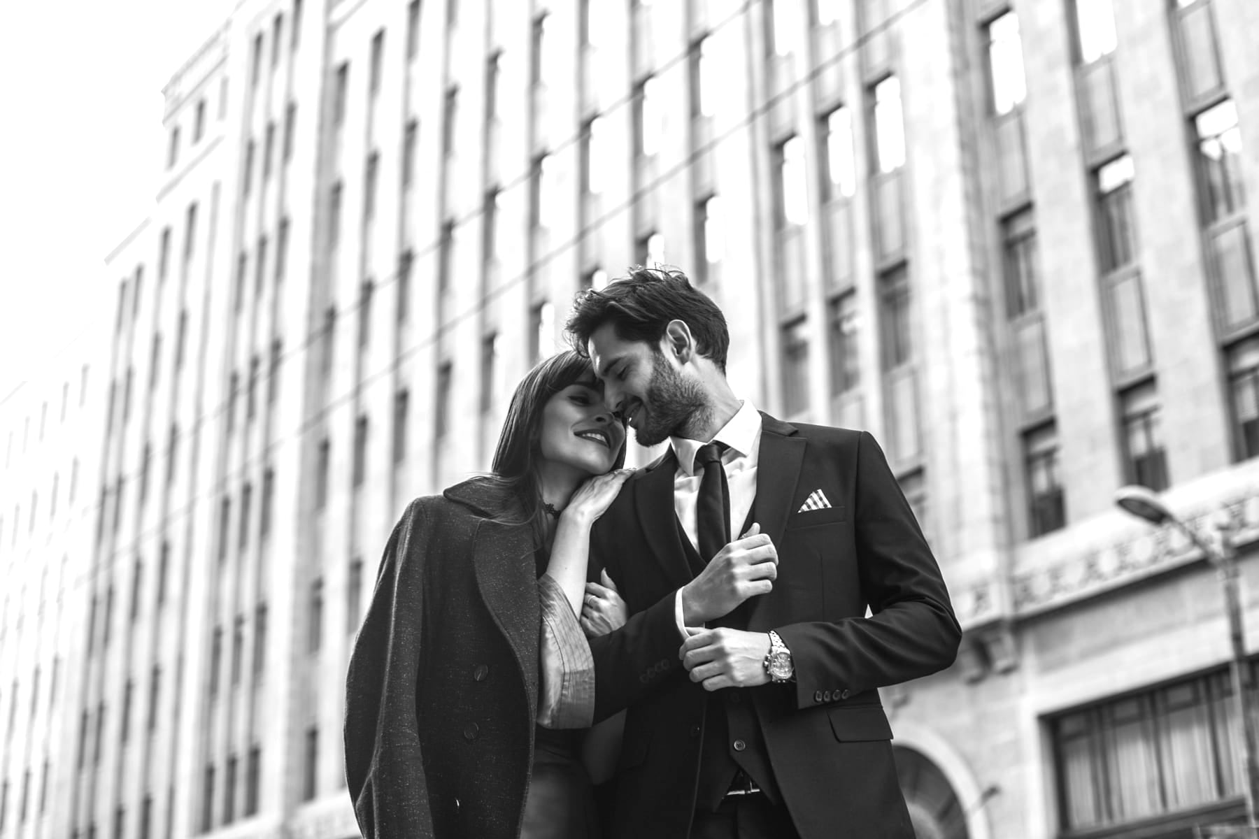 Man and woman embracing in front of a city building in New York City