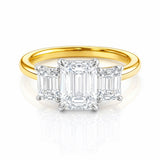 Gold ring with three emerald-cut lab diamonds on a white background