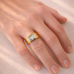 Gold ring with a lab diamond on a hand against a light background