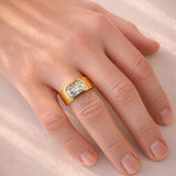 Gold ring with a lab diamond on a hand against a light background