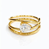Gold ring with a lab grown pear diamond on a white background