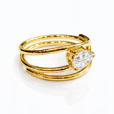 Gold ring with a lab grown pear diamond on a white background