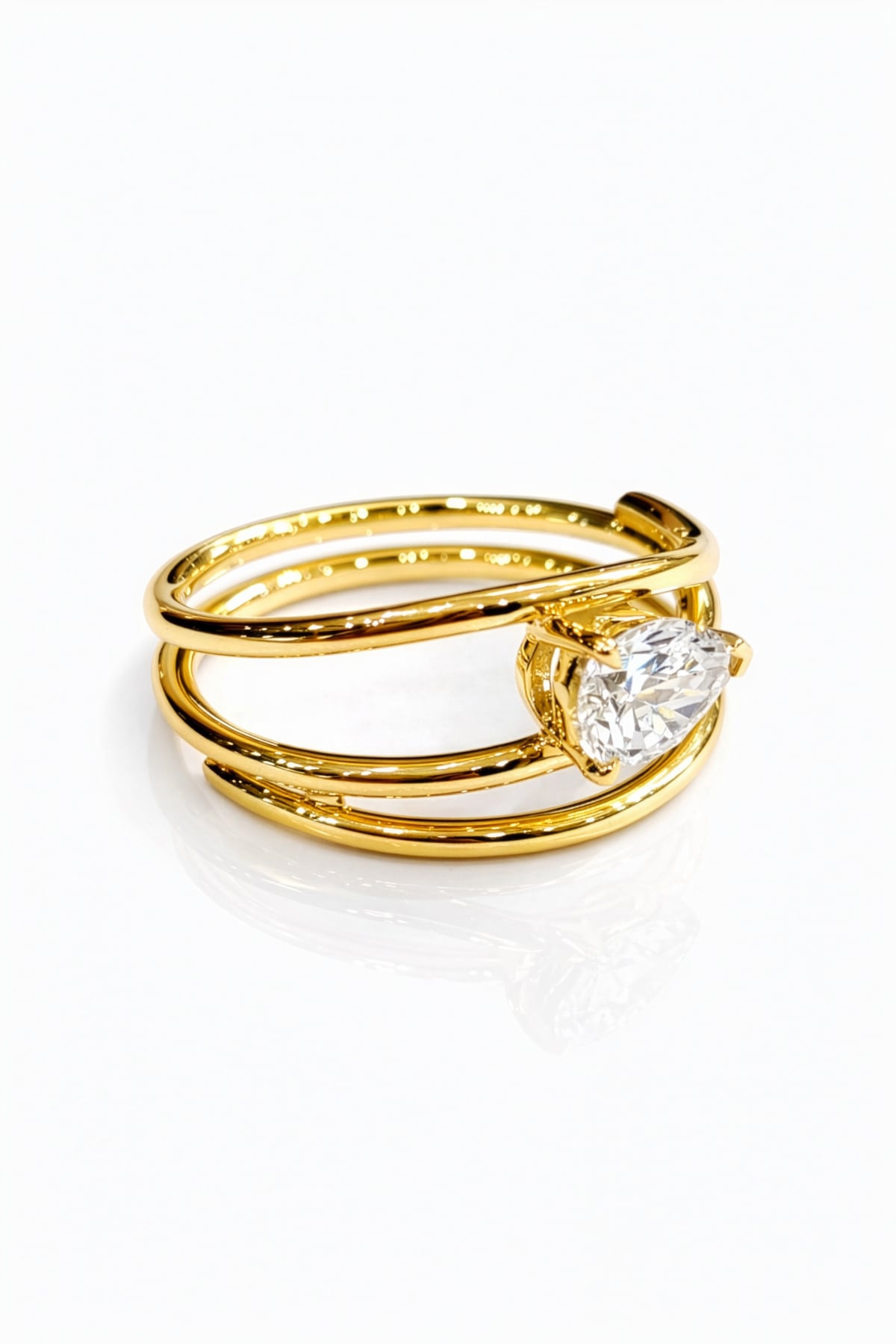 Gold ring with a lab grown pear diamond on a white background