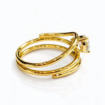 Gold ring with a lab grown pear diamond on a white background