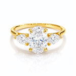 Gold ring with a large lab grown diamond and smaller diamonds on a white background