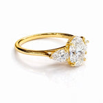 Gold ring with three lab grown diamonds on a white background
