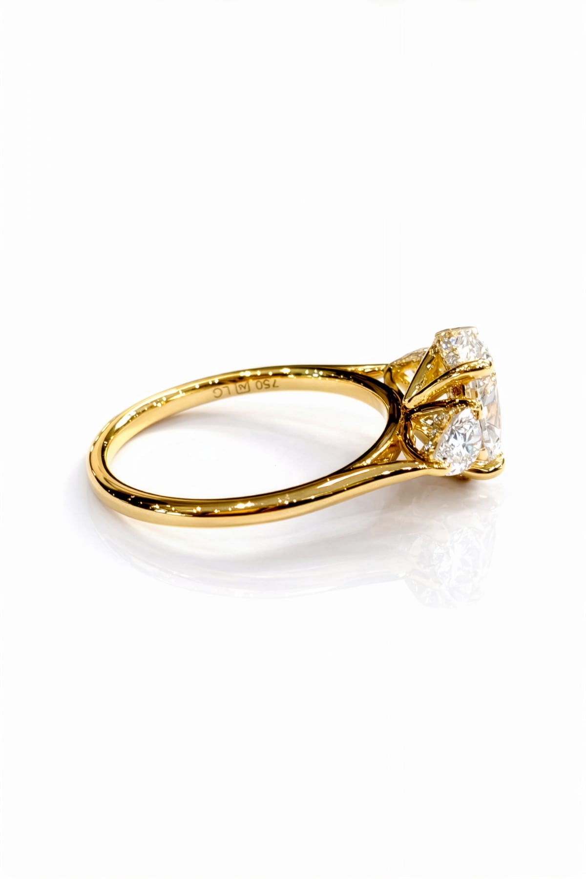Gold ring with a large lab grown diamond and smaller diamonds on a white background
