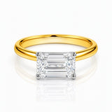 Gold ring with a rectangular lab grown diamond on a white background