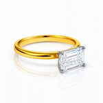 Gold ring with a rectangular lab grown diamond on a white background
