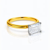 Gold ring with a rectangular lab grown diamond on a white background