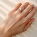 Hand wearing a lab grown diamond ring on a neutral background