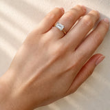Hand wearing a lab grown diamond ring on a neutral background
