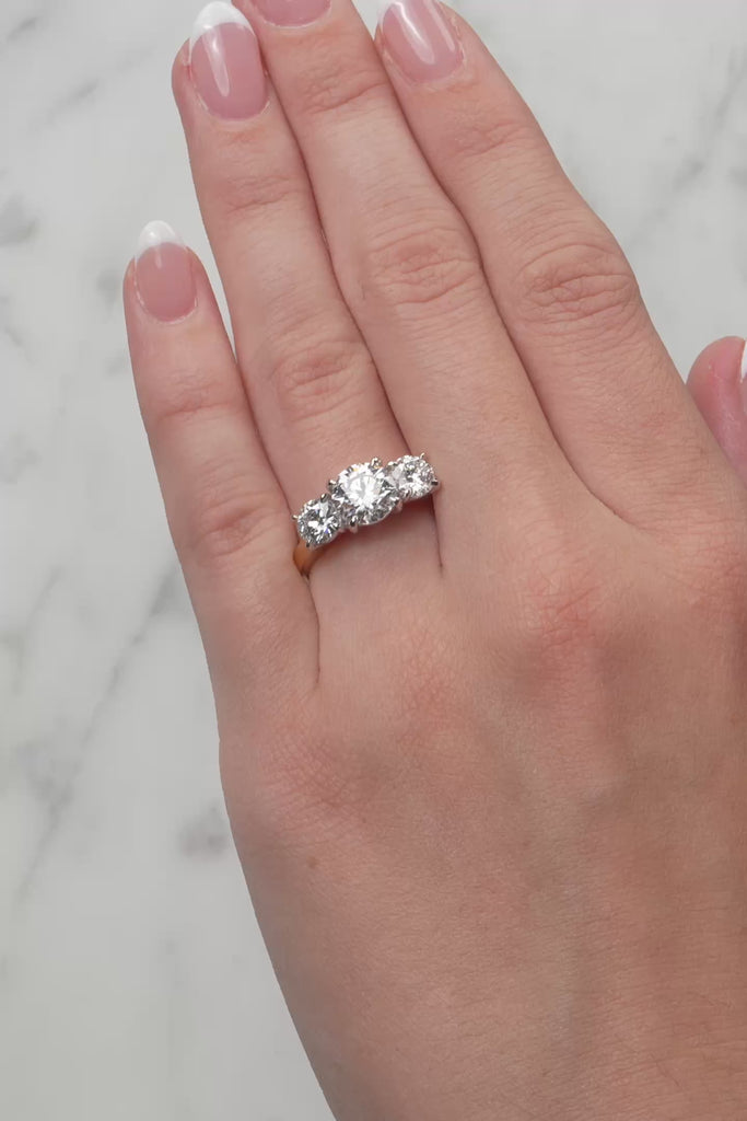 Gold ring with three diamond stones on a white background at LeGassick