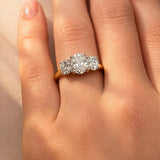 Close-up of a hand wearing a lab diamond ring on a neutral background
