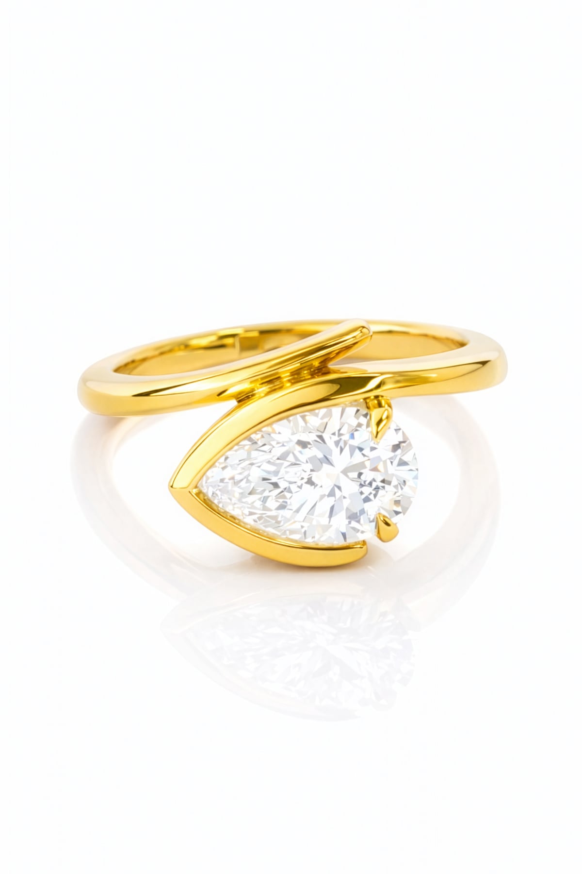 Gold ring with a pear-shaped lab grown diamond on a white background