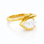 Gold ring with a pear-shaped lab grown diamond on a white background